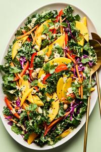 tropical kale salad made with  mango, red cabbage, mint, cilantro, bell pepper, carrots, macadamia nuts and creamy dressing