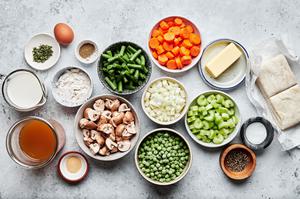 vegetable stock, butter, spices, onion, flour, milk, peas, mushrooms, green beans and pastry dough in prep bowls