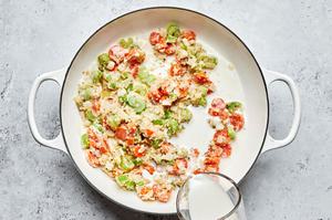 milk being added to a skillet with butter, carrots, celery, onion, flour and spices