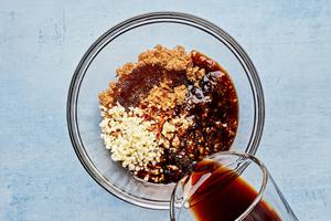 soy sauce, sesame oil, garlic, ginger, brown sugar, red pepper flakes and corn starch being mixed in a bowl