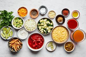 creamed corn, zucchini, enchilada sauce, chiles, canned tomatoes, spices and vegetable stock in prep bowls