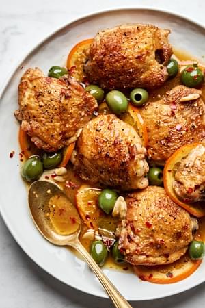Vinegar chicken with oranges and olives, served with a rich sauce and garnished with red pepper flakes.