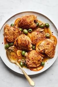 Vinegar chicken with oranges and olives, served with a rich sauce and garnished with red pepper flakes.