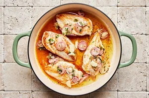 vineyard chicken in a skillet with olive oil, vinegar, shallots, garlic, honey, thyme, and pepper.