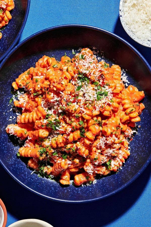 Homemade vodka sauce carbonara on cooked pasta topped with parmesan, fresh parsley and red pepper flakes