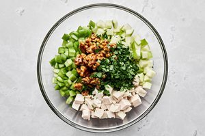 candied walnuts, celery, apples, grapes, chicken and parsley chopped and combined in a glass bowl