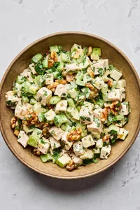 A fresh Waldorf salad made with crisp apples, celery, grapes, candied walnuts, and chicken tossed in a creamy dressing