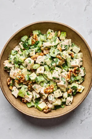 A fresh Waldorf salad made with crisp apples, celery, grapes, candied walnuts, and chicken tossed in a creamy dressing
