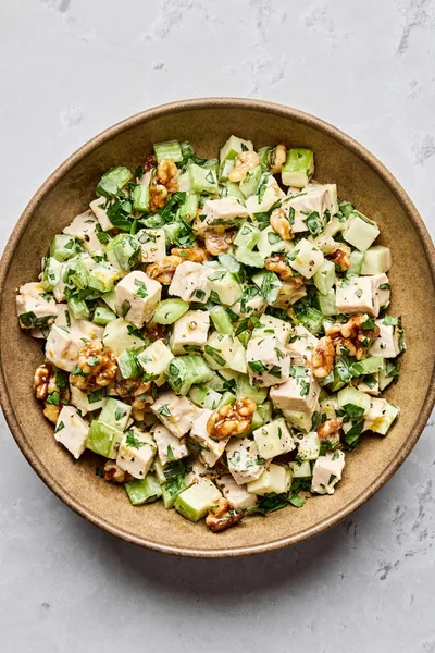 A fresh Waldorf salad made with crisp apples, celery, grapes, candied walnuts, and chicken tossed in a creamy dressing