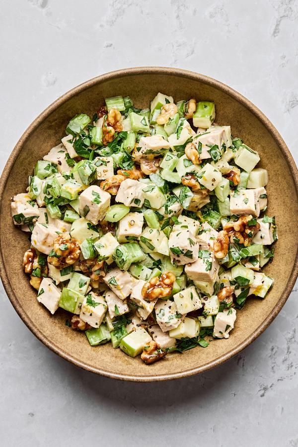 A fresh Waldorf salad made with crisp apples, celery, grapes, candied walnuts, and chicken tossed in a creamy dressing