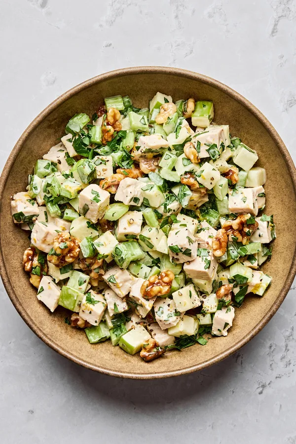 A fresh Waldorf salad made with crisp apples, celery, grapes, candied walnuts, and chicken tossed in a creamy dressing
