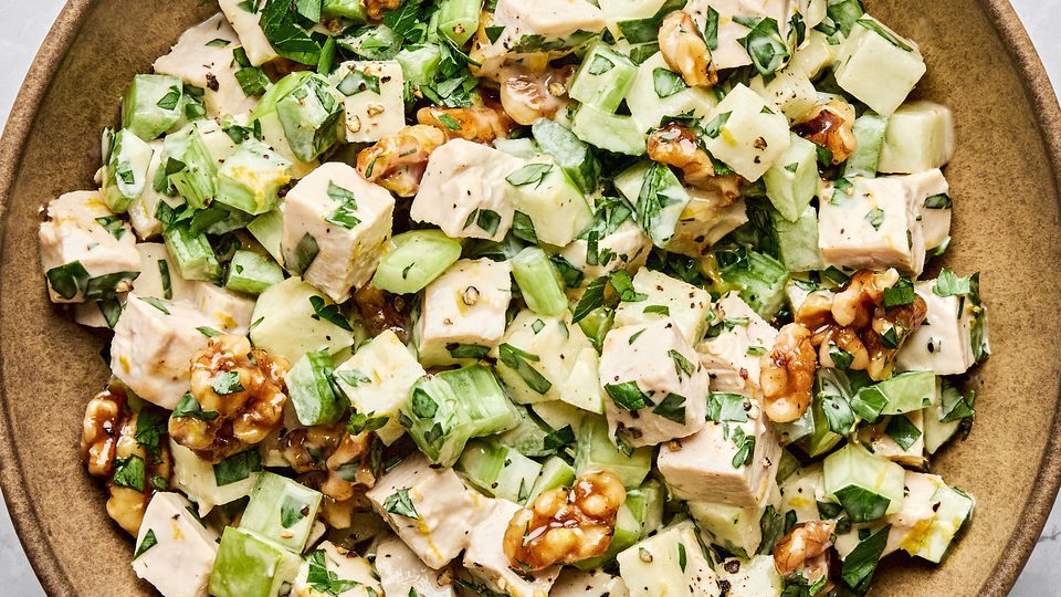 A fresh Waldorf salad made with crisp apples, celery, grapes, candied walnuts, and chicken tossed in a creamy dressing