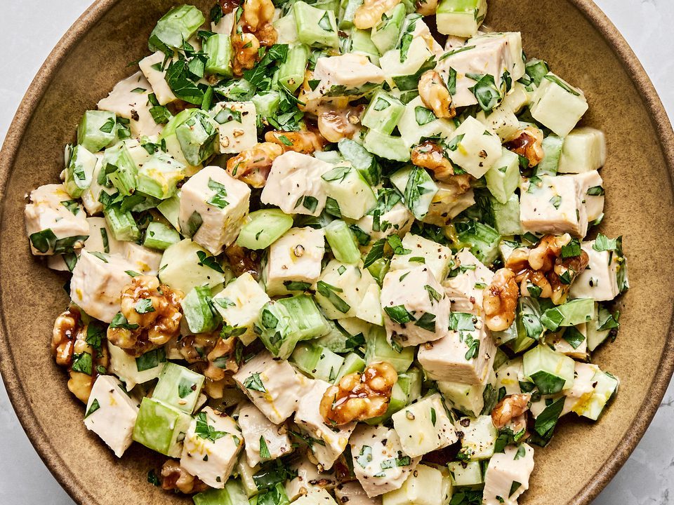 A fresh Waldorf salad made with crisp apples, celery, grapes, candied walnuts, and chicken tossed in a creamy dressing