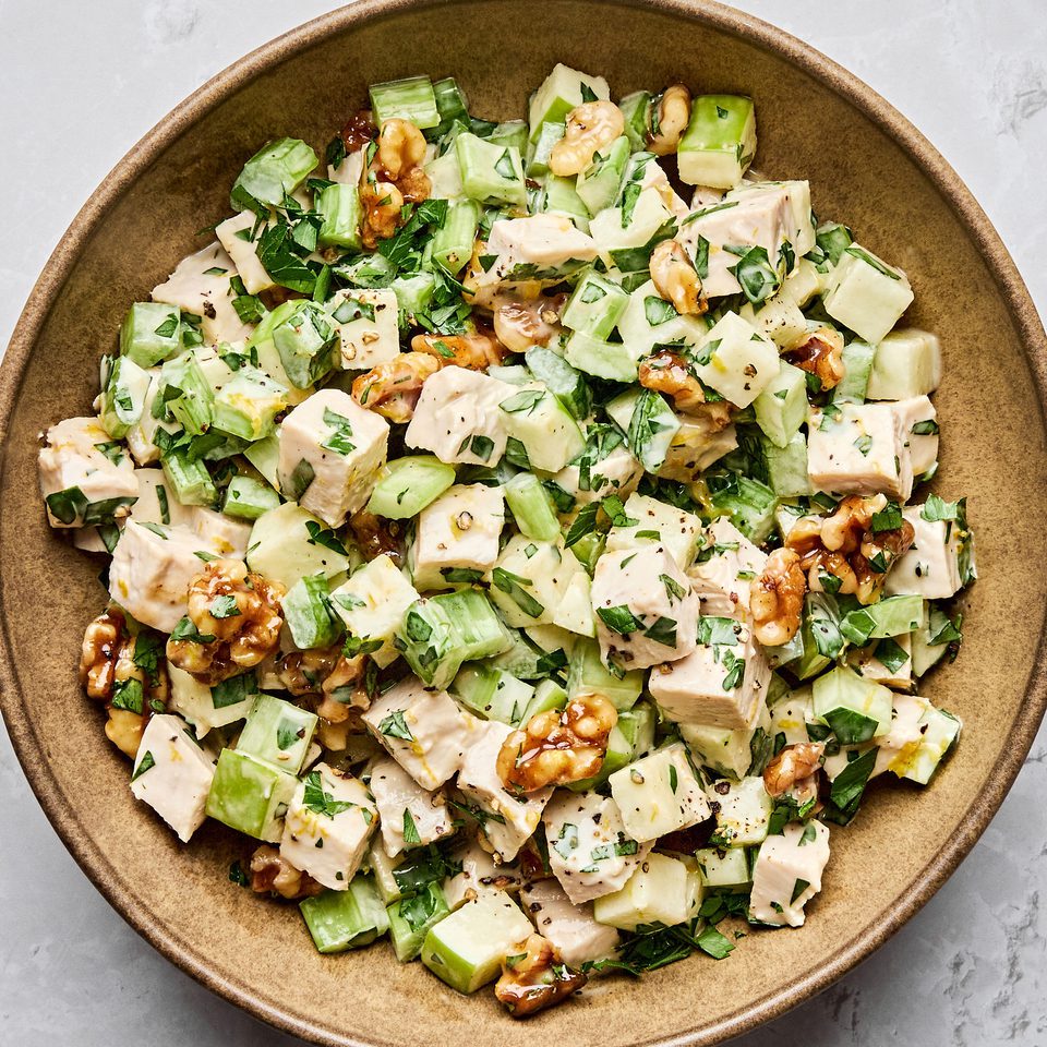 A fresh Waldorf salad made with crisp apples, celery, grapes, candied walnuts, and chicken tossed in a creamy dressing