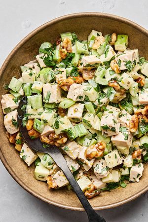 A fresh Waldorf salad made with crisp apples, celery, grapes, candied walnuts, and chicken tossed in a creamy dressing