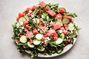 watermelon salad with cucumber, feta, basil and a poppyseed dressing on a plater