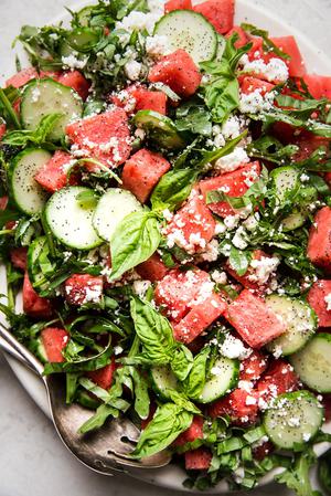 watermelon salad with cucumber, feta, basil and a poppyseed dressing on a plater