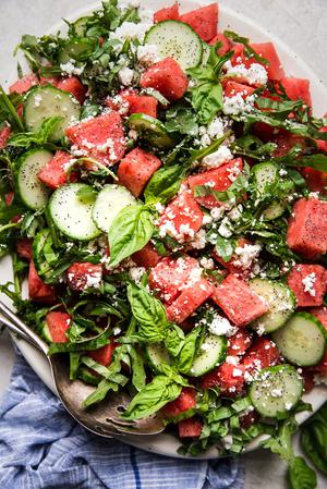 watermelon salad with cucumber, feta, basil and a poppyseed dressing on a plater