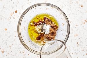 white balsamic vinegar, minced garlic, brown sugar, olive oil, salt, and pepper being combined in a bowl