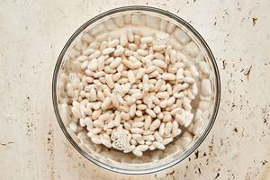 cannellini beans soaking in water in a large bowl