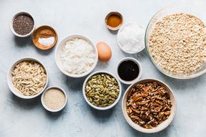 ingredients laid out for homage granola, pecans, oats, maple syrup coconut and almonds