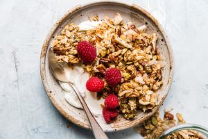 homemade granola in a bowl with yogurt and raspberries