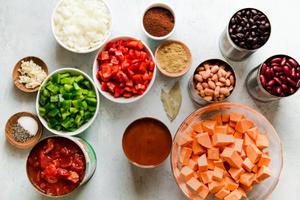 sweet potatoes, black beans, pinto beans, kidney beans, crushed tomatoes, bell pepper, onion and spices in prep bowls
