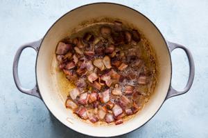 Bacon being cooked in a soup pot